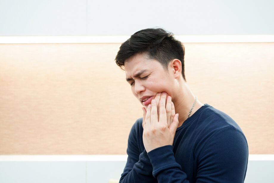 Man Holding Jaw In Pain From Wisdom Tooth Infection